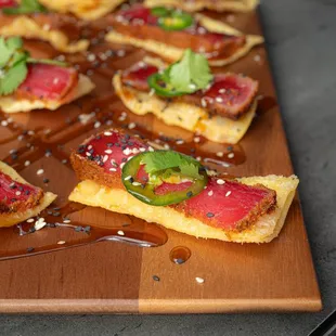 a wooden cutting board topped with slices of pizza