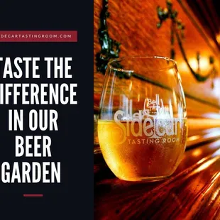 a glass of beer with the words taste the difference in our beer garden