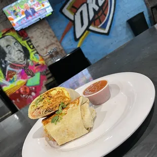 a burrito with a side of salsa