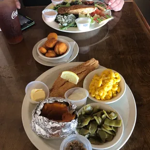 Catfish lunch special with sweet potato , green beans, Mac and cheese fries squash and the second plate is salmon salad