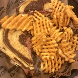 Reuben sandwich with waffle fries.