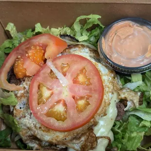 Single patty burger with egg and vegetables minus the bun.