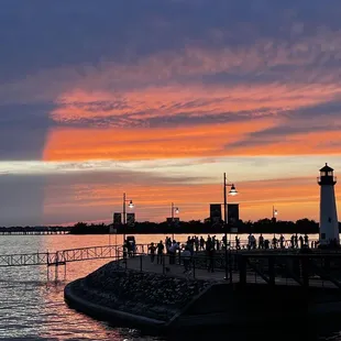 a lighthouse on a pier at sunset