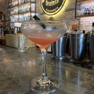 a pink cocktail in a martini glass