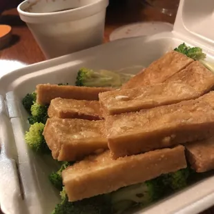 tofu and broccoli in a styrofoam container