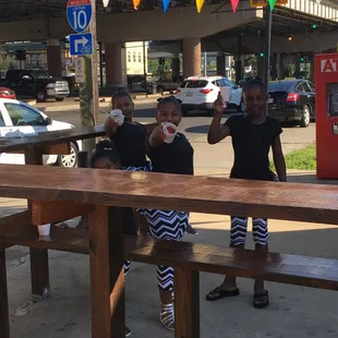 three children sitting at a picnic table