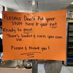 a sign stating customers don&apos;t put your stuff here if you&apos;re ready to pay