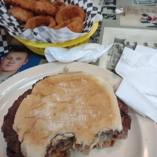 a half eaten burger and onion rings