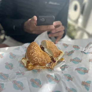 a man taking a picture of a sandwich