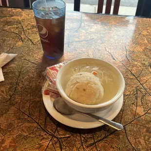 a bowl of soup and a glass of soda