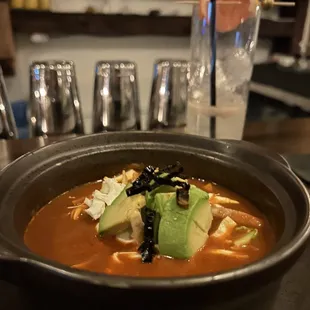 a bowl of soup with avocado