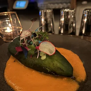 a cucumber on a plate with sauce