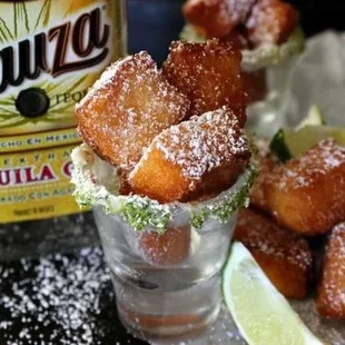 a shot of a margarita with sugared donuts