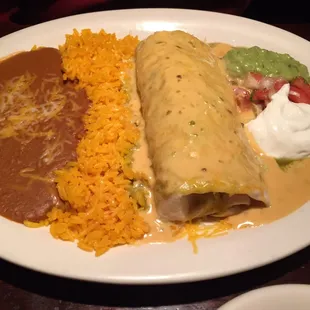Burrito with cheese sauce on top.