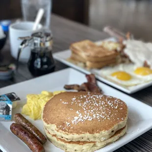 a breakfast of pancakes, eggs, sausages, and sausages