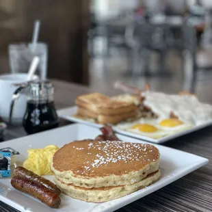a breakfast of pancakes, eggs, sausages, and sausages