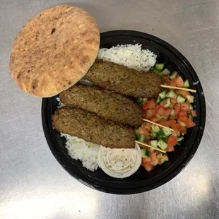 a plate of meat skewers and rice