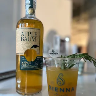 a glass of apple baum and a bottle of apple baum