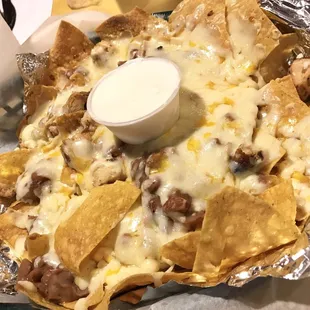 [ NACHOS ] freshly made corn chips topped with blended cheeses, refried beans, sour cream and salsa.