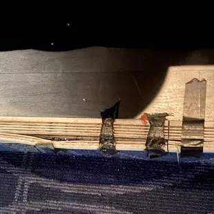 On the step under the chairs