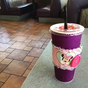  purple cup with a mickey mouse sticker on it
