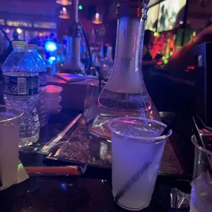 a glass of water and a bottle of water on a bar