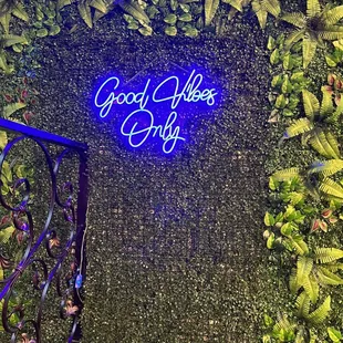 a neon sign in front of a green wall