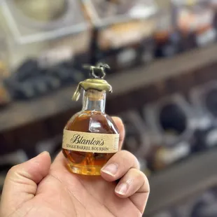 a hand holding a bottle of brandy