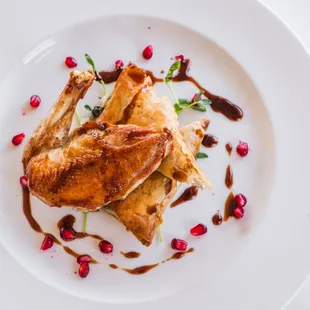 Pan-seared pheasant breast, Spanakopita stuffed with chèvre and pheasant confit with pomegranate sauce