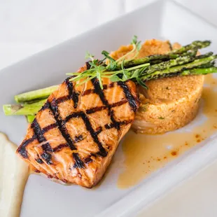 Grilled salmon marinated in Soyaki, kimchi couscous, asparagus, chili oil, and wasabi aioli