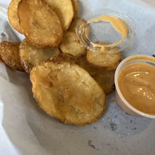 a plate of fried potato chips and dipping sauce