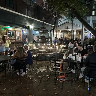 a crowd of people sitting at tables outside
