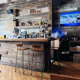 a bar with wooden walls and bar stools