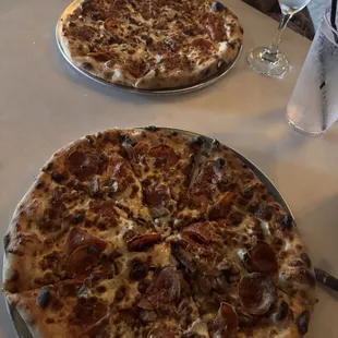 Pepperoni and sausage pizza and a pepperoni pizza. French 75 mixed drink.