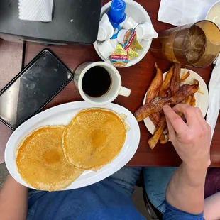 a breakfast of pancakes, bacon and eggs