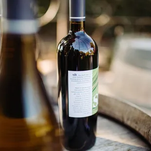 two bottles of wine on a barrel