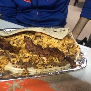 Don Silva's breakfast taco: beans, chorizo, bacon, cheese. For reference look at the skinny arm compared to the giant taco.