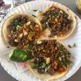three tacos on a paper plate