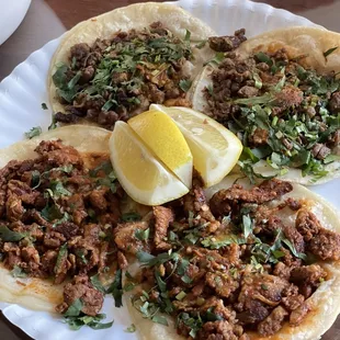 Front: Two pastor tacos ($2 each) Back: Two carne asada tacos ($2 each)