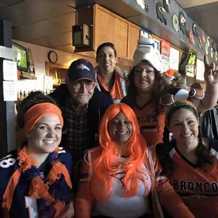 a group of people wearing orange wigs