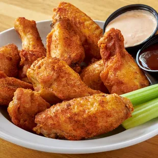 a bowl of chicken wings and celery sticks