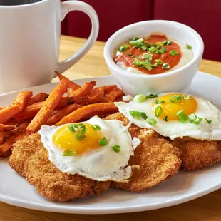 a plate of fried eggs and sweet potato fries