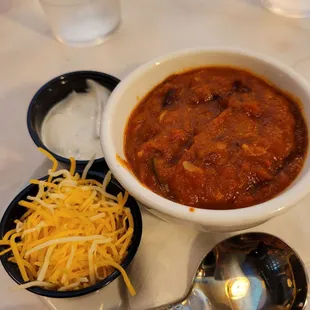 veggie Chilli in a cup with cheese and cilantro sour cream