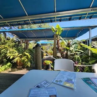 a table and chairs with a blue awning