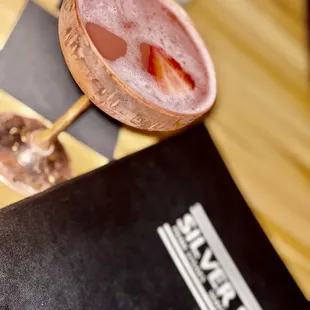 a pink cocktail with strawberries