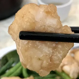 chopsticks holding up a piece of fried shrimp
