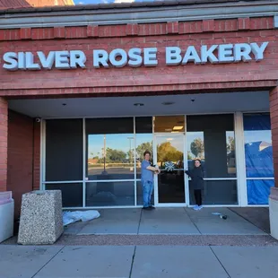 Priscilla Sweet and Michael Sweet under the Silver Rose Bakery sign.