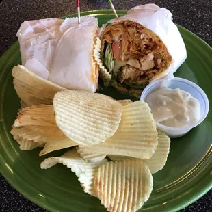 a sandwich and chips on a green plate
