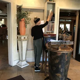 a woman placing a piece of paper in a vase