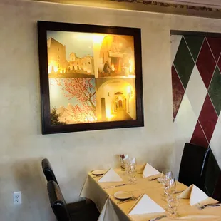a dining room with a painting on the wall